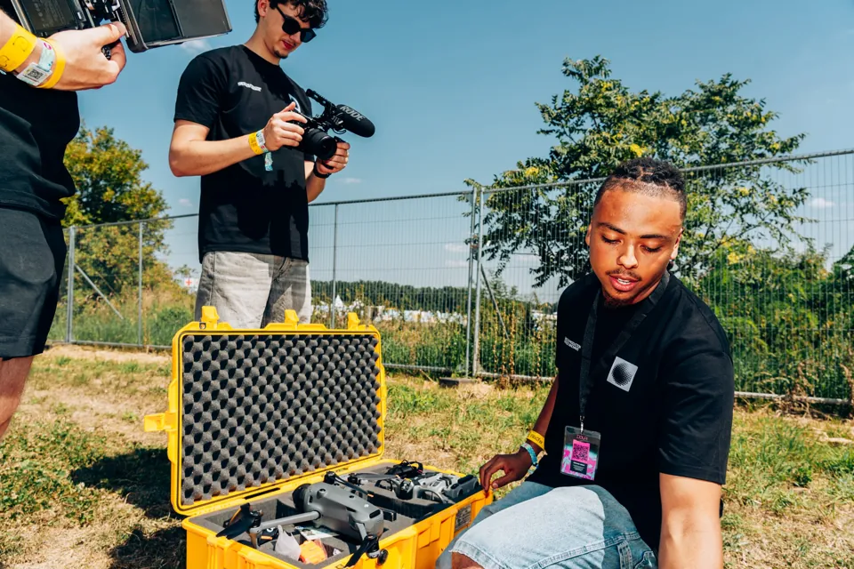 Équipe drone en préparation sur un site de festival extérieur